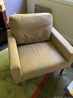Front view of the Raleigh armchair showing tan wool upholstery and thick cushions.
