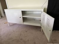 White metal Ikea locker cabinet with one door open, showing interior shelf and ventilation slots.