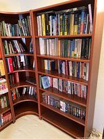 Corner bookshelf holding a collection of English books including fiction and nonfiction.