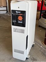 Front angled view of white DeLonghi oil filled heater showing control panel and ventilation slots.