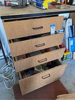 Four drawers partially open showing the packed hardware items inside with some items spilling out