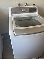Front view of white LG top load washing machine showing overall condition and glass lid.
