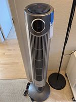 Full view of the Ozeri tower fan, showing its height and general condition, with power cord coiled at the base.