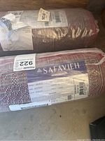 Two rolled Safavieh Adirondack area rugs in original plastic packaging showing brand and product tags.