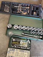 Three tool sets in their cases showing sockets, ratchets, wrenches, pliers, and hammer