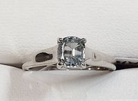 Front view of 10 Kt gold ring with cushion-cut light blue sapphire stone.