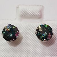 Front view of pair of round-cut moissanite stud earrings set in 10K white gold four-prong settings, showing multicolored reflections in stones.