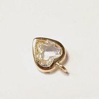 Close-up photo of heart-shaped moonstone pendant set in 10K yellow gold bezel.