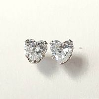 Close-up view of heart-shaped clear cubic zirconia stones in 14K white gold settings showing front details and prong settings.