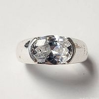 Front view of silver ring with oval cubic zirconia stone showing the faceted stone and smooth band.