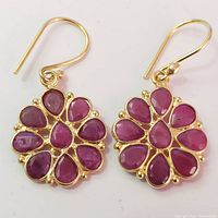 Front view of ruby cluster earrings showing faceted stones and gold tone metal.