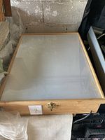 Top view of the light box showing frosted acrylic surface framed by natural wood edges with latch and white on/off switch.