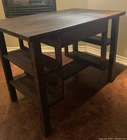 Side view of mission style oak desk showing two shelves on each side and the structure of the legs and frame.