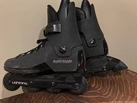Side view of black Rollerblade Lightning inline skates showing wheels and branding