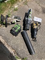 Five power tool components arranged on pavement
