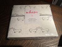 Photo of Whim twin sheet set in original sealed packaging, showing the label with brand name and product details.