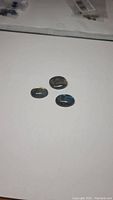 Three oval polished labradorite cabochon gemstones with visible iridescence and color flashes.