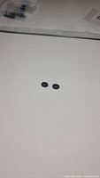 Two oval jet black onyx stones side by side on a white background