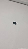 Oval cut natural blue sapphire gemstone displayed against a plain background highlighting its deep blue color and size.
