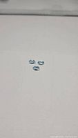 Three natural sky blue oval cut topaz gemstones, clear and faceted, placed on a white surface, showing size and clarity.
