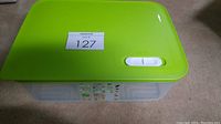 Top view of green lid with white vent slider on storage container.