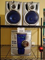 Front view of Kenwood stereo system main unit and dual bookshelf speakers on shelf