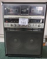 Front view of The Singing Machine SM-7700 showing dual cassette decks and controls with a lot number tag
