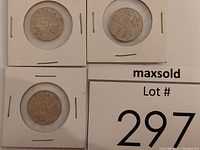 Three Canadian five cent coins displayed in individual white cardboard holders, showing reverse sides with date and maple leaf details.