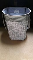 Front view of the Thirty-One Stand Tall Bin showing grey woven fabric exterior and side handles.