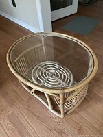 Oval rattan side table viewed from above showing the glass insert and rattan frame.