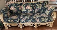 Front view of three-seat rattan sofa with floral cushions