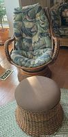 Full view of rattan swivel chair with attached floral cushion and round ottoman.