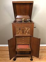 Front view of open cabinet showing carved lattice front, record storage drawers and lower compartment