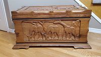 Front panel showing carved elephants, giraffes and rhinoceroses grazing