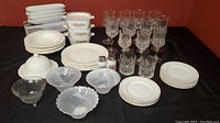 Image of entire lot showing crystal glasses, ceramic plates and bowls, frosted glass bowls, salt & pepper shakers, and Corningware dishes.