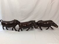Photo showing the full side view of the connected 3 warthog wood carving set, showcasing length and shape.