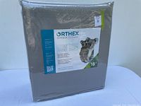 Front view of Orthex Symbia posture cushion, packaged, showing label with koala and 18° angle.
