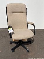 Front view of beige fabric office chair showing padded seat, cushioned high backrest, and black metal armrests with fabric padding.