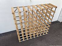 Full view of wooden slat and galvanized steel frame wine rack designed for 64 bottles