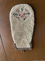 Front view of eyeglass case showing beadwork and floral embroidery