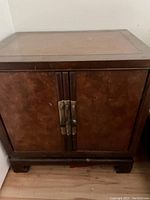 Front view of vintage Drexel Heritage Asian style wooden night stand with two doors and metal handles.