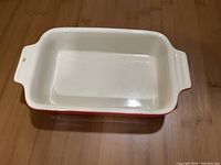 Top view showing the interior and handles of the small rectangular baking dish, red exterior and cream interior