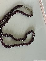 Photo of the garnet bead choker necklace showing the overall strand and the metallic clasp closure.