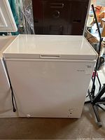 Frigidaire white chest freezer closed showing front and side vents with attached power cord.