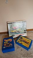 Photo showing the three main lot items: two blue carrying cases and one vintage Chevrolet Road Rally box