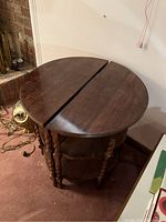 Two half-moon wood side tables placed together to form a round table, showing the top surface and legs.