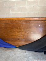 Photo showing the solid oak surface of the conference table with warm medium-brown finish and partial covering.