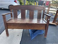 Front view of heavily used wooden entryway bench with scratches and surface wear.