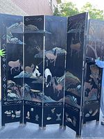 Full view of the 5-panel folding screen showing horses, birds, and landscape motifs inlaid on black background.