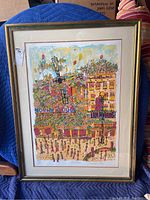 Full view of the framed artwork depicting the Moulin Rouge with colorful crowd scene, signed limited edition print.